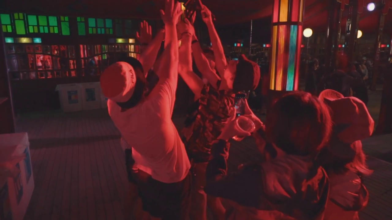 붉은 조명 아래 Palace of Wonder에서 손을 맞댄 관객들